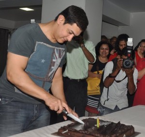 49 वें जन्म दिन पर अपने घर पर केक काटते आमिर।